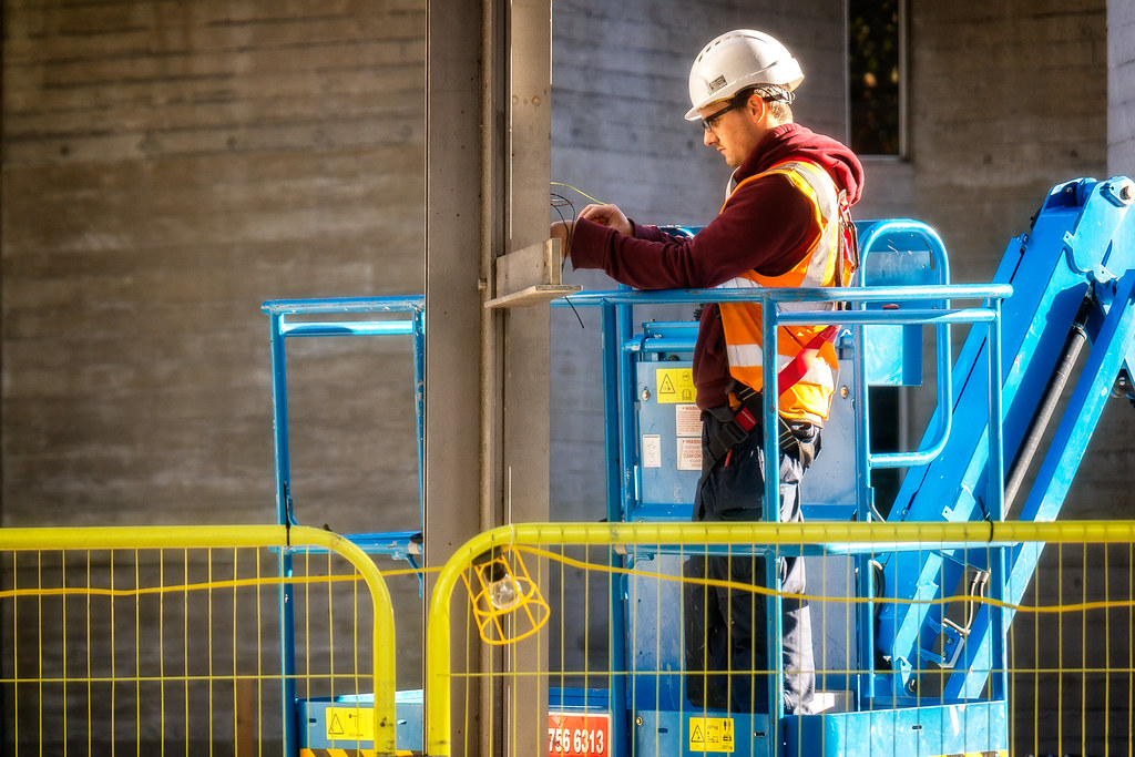 Electrician working at height on a commercial building